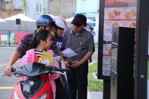 71312_Customersonscooterslearninghowtoorderatthedrive-thruatthefirstMcDonaldsdrive-thrurestaurantinVietnam