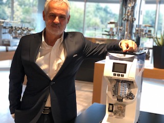 Fabio Ceccarani, 60 anni, è l'amministratore delegato del Simonelli Group. Qui è nello show room-museo della Victoria Arduino accanto al nuovissimo macinino on demand di ultima generazione Mythos 2 che sta diventando un oggetto di culto