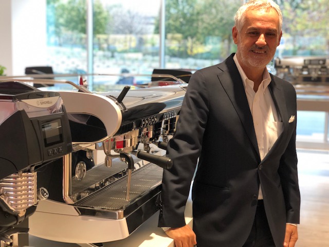 Fabio Ceccarani, 60 anni, è l'amministratore delegato del Simonelli Group. Qui è nello show room-museo della Nuova Simonelli accanto alla nuova Wave e al macinino on demand di ultima generazione Mythos 2